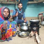 Beneficiary and Digital Runner showing thumbs up after Receiving Improved Cookstove under Anaxee's Clean Cooking Initiative
