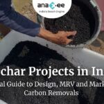 Field worker's hand pouring granular biochar from a bucket into a white tub; granular black biochar ready for soil application in a rural pilot.